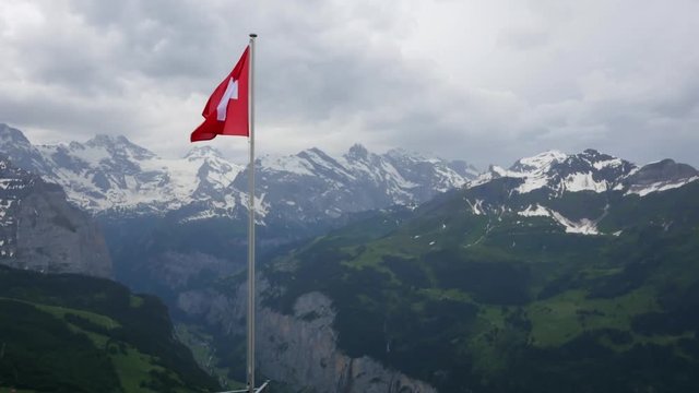 Swiss flag fluttering in the Alps
