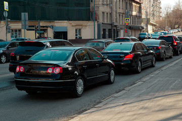 Obraz na płótnie Canvas Narrow city oad with cars in traffic jam. Red traffic light.