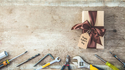 Father's Day. Gift box with a tag , tools on a wooden background Copy space Top view Banner concept.
