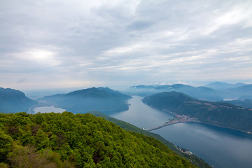 Obraz premium Balcony of Italy - Panorama of Lake Lugano in cloudy day. Alps with Mount blanc in background. Lombardia, Italy