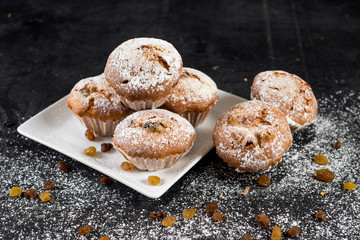 Delicious cupcakes with raisins on wooden background