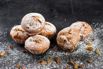 Delicious cupcakes with raisins on wooden background