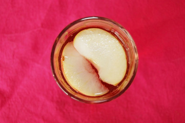 A delicious summer drink with slices of apples in a glass cup