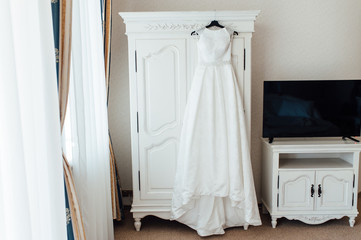 Fototapeta na wymiar Wedding dress hanging on the cupboard