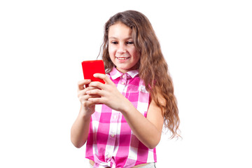 Cute little girl looks in smartphone and smiling