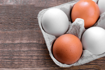 Brown chicken eggs in a tray for eggs on a brown wooden background