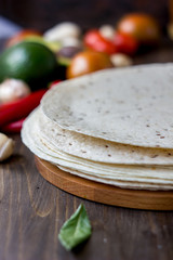 Mexican flatbread tortilla on wooden background.