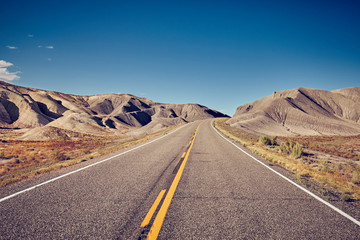 Vintage toned picture of a deserted road, travel concept, USA.