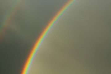 Fototapeta premium A beautiful bright rainbow and dark rain clouds. Close-up. Background. landscape.