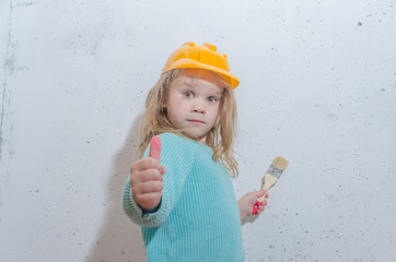 girl in a helmet paints the wall