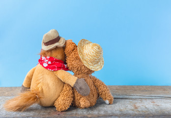 Friendship, teddy bear holding plush horse in its arms