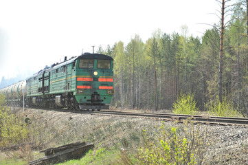 Obraz premium Trunk two-section locomotive, going by rail with freight cars. A train. Railway. Russia.