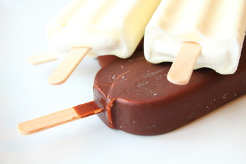 Creamy ice cream on a stick in chocolate glaze and white glaze. Eskimo. Close-up. Background.