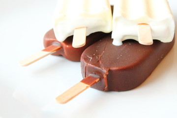 Creamy ice cream on a stick in chocolate glaze and white glaze. Eskimo. Close-up. Background.