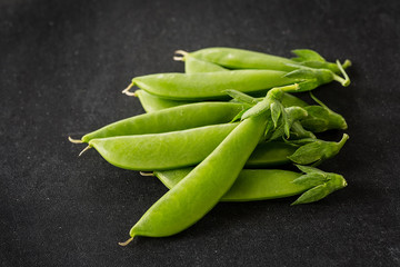 Freshly picked snow peas on a black background.