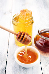 Pouring aromatic honey into jar, closeup