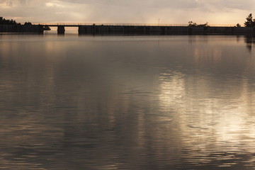 sunset in the Revenga reservoir, Segovia, Spain. Golden and silver tones with reflections in the water. Calm scene.
