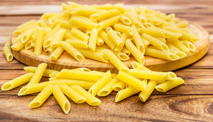 Cutting board with raw pasta on wooden table. Close up.