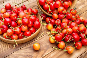 Heap of cherries and bowls with cherries on the table. Generous harvest. Healthy eating.