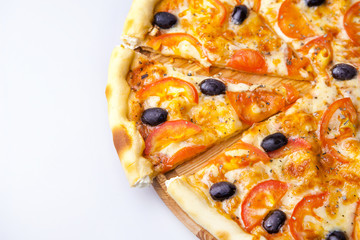 pieces of pizza with olives, cheese and tomatoes is laying on the board in the pizzeria
