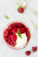 Strawberry Sunday with raspberries, decorated with mint leaves and served in a classic old glass goblet.