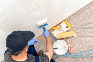 House painter at work painting a wall with a brush © francescomou