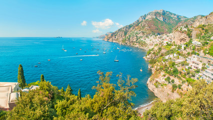 Obraz premium secluded beach and green coastal town with sea and mountains