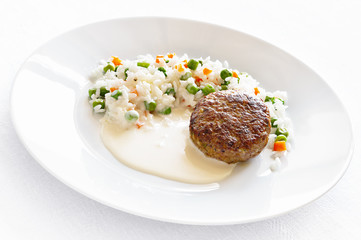 fried meatball garnished with rice cooked with vegetables and white sauce
