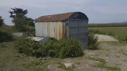 Run down old rusty corrugated tin shed surrounded by weeds in a field Appledore North Devon United...