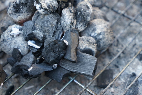 Glowing coals to hotdog grill with a charcoal barbecue in the garden
