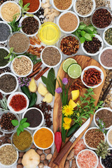 Herb and spice seasoning with fresh and dried herbs, spices and edible flowers on olive wood board and rustic background  Top view.
