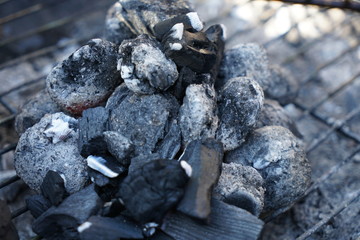 Glowing coals to hotdog grill with a charcoal barbecue in the garden
