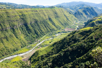 Fototapeta premium Intag Valley from the ground looking at the river Intag and houses with blue sky in Ecuador near Otavalo