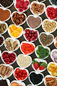 Health food for a healthy heart with vegetables, fruit, fish, nuts, seeds, supplement powders, cereal and  herbs for herbal medicine. High in omega 3 fatty acid, anthocyanins, fibre & antioxidants. 