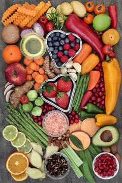 Health food for fitness concept with fresh fruit, vegetables, herbs, spices, nuts, himalayan salt and olive oil. High in antioxidants, fibre, smart carbohydrates, anthocyanins, minerals and vitamins.