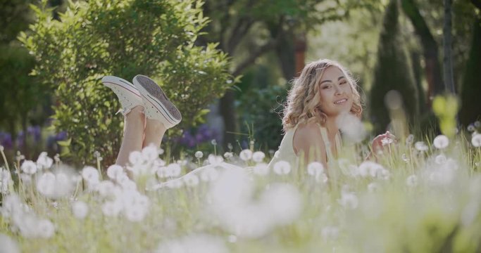 beautiful Asian girl on the grass in the Park on a Sunny day with a book