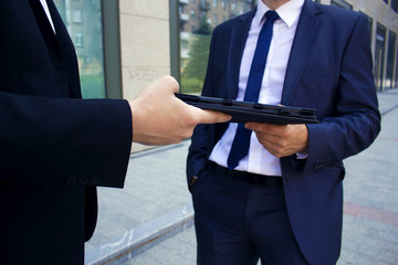 .men hand over to each other in the hands of an electronic book