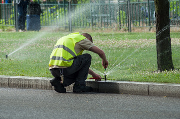 transportation company employee adjusting automatic sprinklers on tramway line - 209396568
