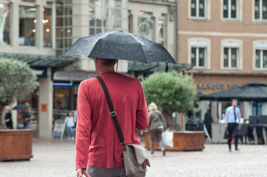 portrait of man with umbrella on cobbles place  in the city