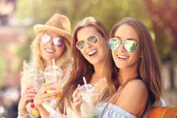 Happy girl friends hanging out in the city in summer