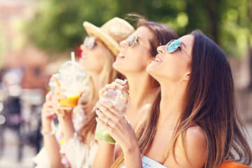 Happy girl friends hanging out in the city in summer