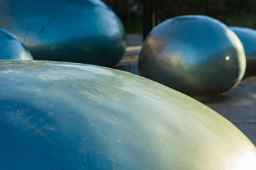 Beautiful oval turquoise rain drop sculptures with reflections near inner city centre of...
