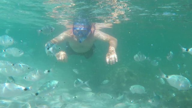 Young attractive man snorkeling in green lagoon.