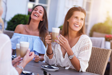 Happy girl friends in cafe during summer time