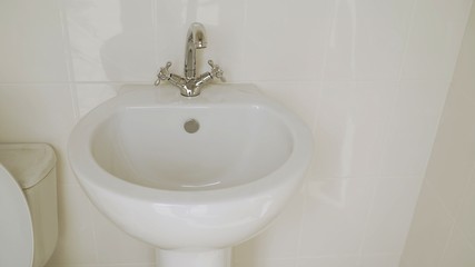 White shell. A new white sink. Clean white sink with a faucet.