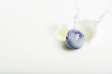 The berry falling into the milk.