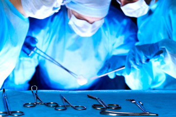 Group of surgeons in masks performing operation. Medicine, surgery and emergency help concepts