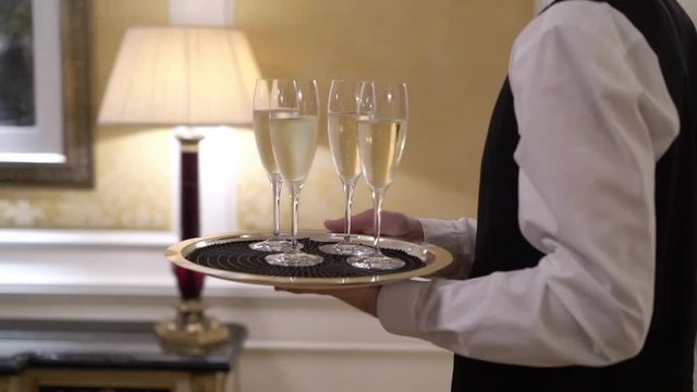 Waiter holding plate with glasses of champagne at the party