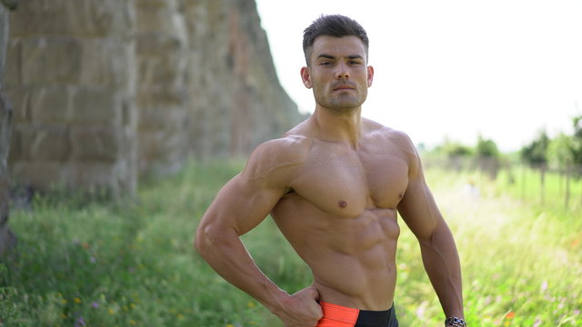 young guy with an athletic figure and muscles. part of body: abs and biceps.