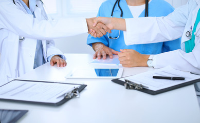 Two doctors shaking hands to each other at meeting. Teamwork and agreement in medicine